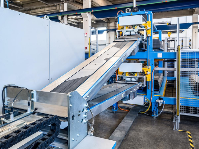 Metal processing facility conveyor with steel rollers and timing belts